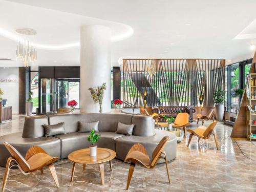 a lobby with a couch and tables and chairs at Movenpick Resort and Spa Fruske Terme in Vrdnik