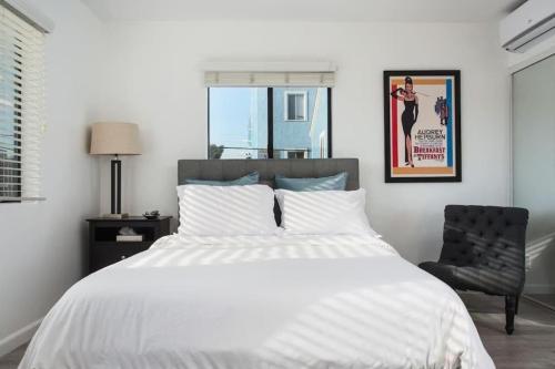a bedroom with a white bed and a chair at Sunny Studio in the Heart of Venice Beach - #6 in Los Angeles