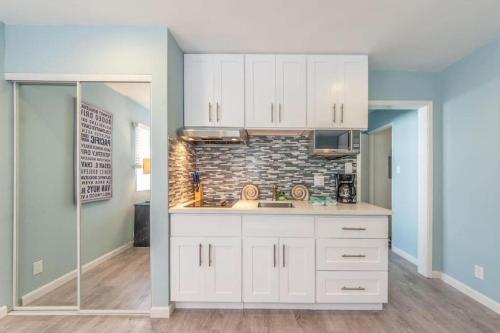 a kitchen with white cabinets and a brick wall at Sunny Studio in the Heart of Venice Beach - #6 in Los Angeles
