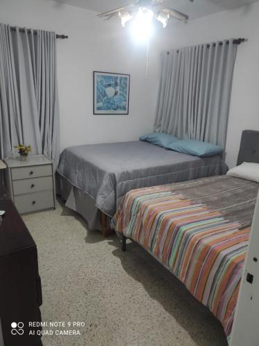 a bedroom with two beds and a dresser at Sweet beach apartment in San Felipe de Puerto Plata