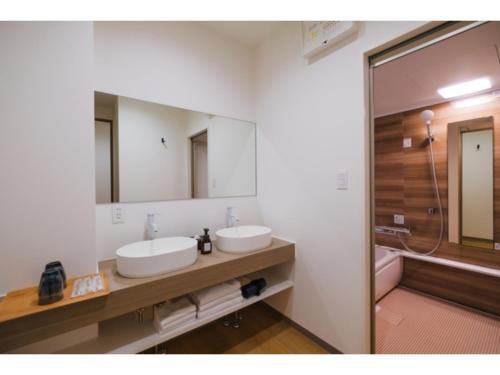 a bathroom with two sinks and a mirror and a tub at HOTEL ALL IN Kumamoto - Vacation STAY 55107v in Hanabatachō