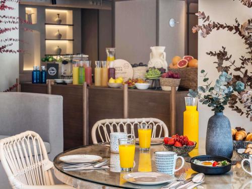 una mesa con sillas y una mesa con jugo de naranja en Mercure Benidorm, en Benidorm