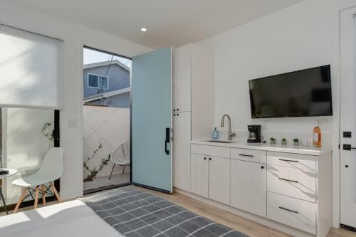 a kitchen with white cabinets and a flat screen tv at Brand New Studio in Mar Vista in Los Angeles