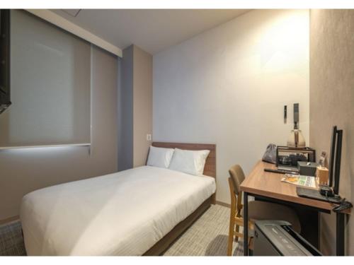 Una habitación de hotel con una cama y un escritorio y una cama y un escritorio en Hotel Reference Kokura Ekimae - Vacation STAY 56106v, en Kokura