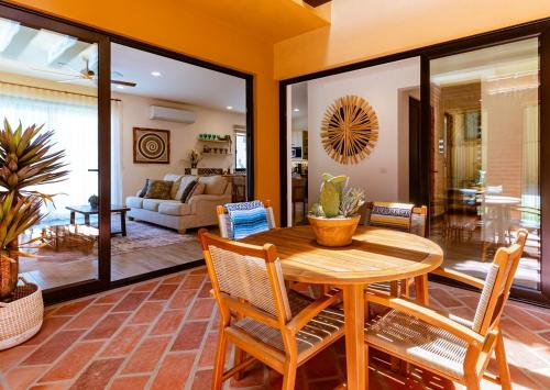 a living room with a wooden table and chairs at Inviting 2BR Condo in Mavila Resort at Quivira in Cabo San Lucas