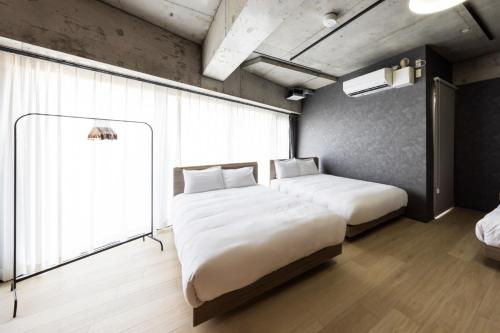ein Schlafzimmer mit zwei Betten und einem Fenster in der Unterkunft AMP FLAT ARCBLISS 3 - Vacation STAY 57123v in Chikushino