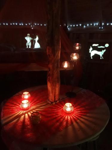 a table with red lights on it in a dark room at Les Cabanes De Pyrene in Cazarilh