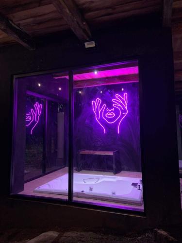 a window with purple lights in a room with a tub at La Cabaña 16 Mazamitla in Mazamitla