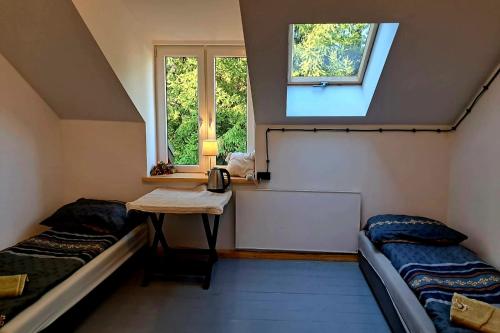 a room with two beds and a table and a window at Stara Szkoła S7 Noclegi Mazury, Zajezierze 8 14-330 Małdyty in Małdyty