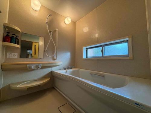 een badkamer met een bad, een toilet en een raam bij Ocean View Mt, Kaimondake - Vacation STAY 58439v in Oka-chiyogamizu