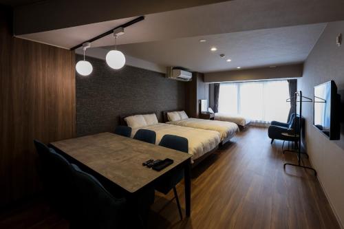 a hotel room with a bed and a dining table at AMP FLAT ARCBLISS 2A - Vacation STAY 57446v in Chikushino