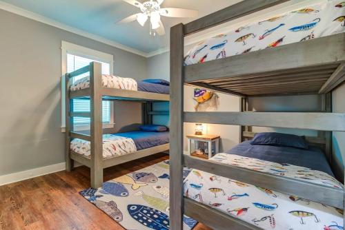 Un dormitorio con dos literas y un ventilador de techo. en Waterfront Holiday and Mardi Gras escape, en Bay Saint Louis