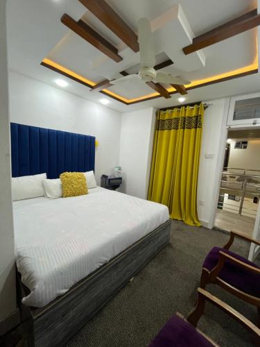 a bedroom with a large bed and a yellow curtain at HR Guest House in Gilgit