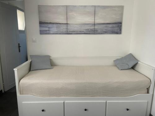 Una cama en una habitación con dos almohadas encima. en L'Oseraie, en Moisenay