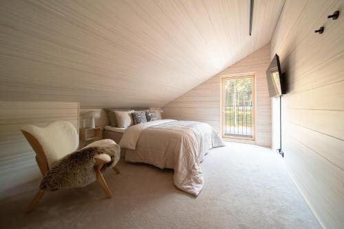 a attic bedroom with a bed and a window at Arctic Design Villa Levi in Levi