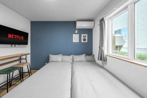 a bed in a room with a blue wall at Charmant House III - Vacation STAY 20373 in Minamifurano
