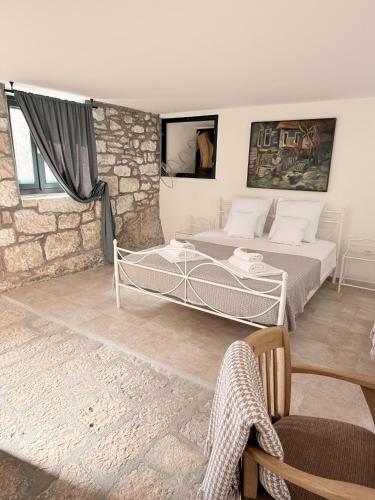 a bedroom with a bed and a stone wall at Humac Vero Apartments in Donji Humac