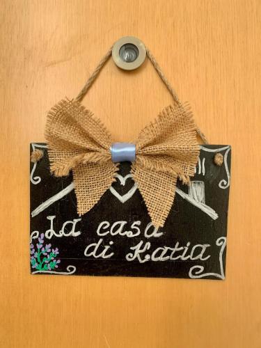 a sign with a bow is hanging on a wall at La Casa di Katia in Mantova