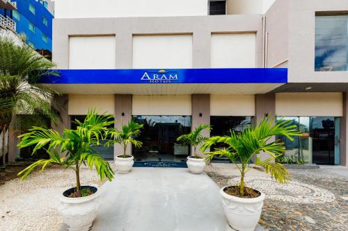 Un edificio con palmeras delante. en El Aram Beach Express, en Maceió