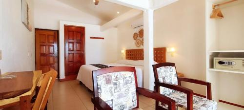 a bedroom with a bed and a table and chairs at Posada Ziga Playa in Mazunte
