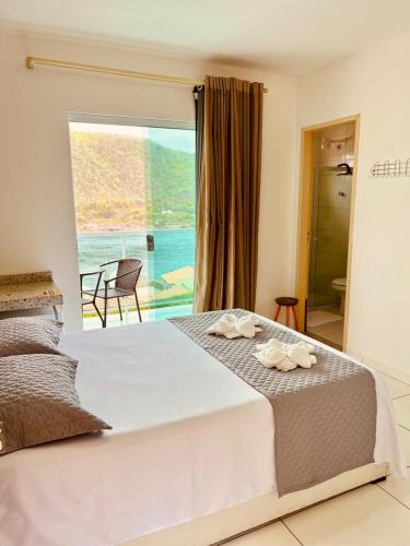 a bedroom with a bed with a view of the ocean at Pousada Lampião Rio in Piranhas