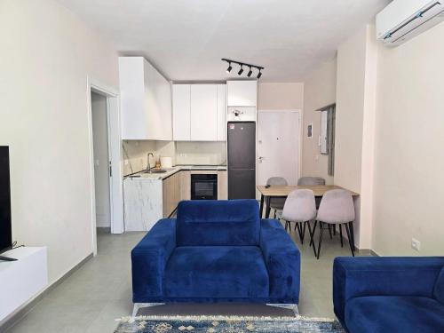 a living room with a blue couch and a kitchen at Mira Apartment in Tirana