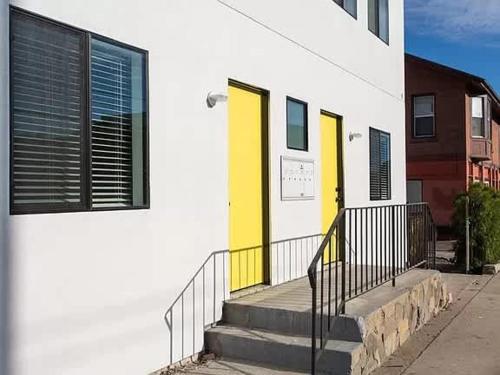 a building with yellow doors and stairs on a street at Sunny Studio in the Heart of Venice - A in Los Angeles