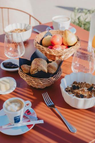 Fargues-Saint-HilaireにあるSainte Raphineのパンの入ったバスケットとコーヒーカップが置かれたテーブル