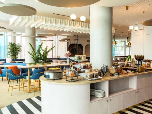 Un restaurante con mostrador, sillas y mesas. en Mercure Dunkerque Centre Gare, en Dunkerque