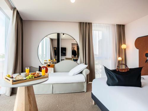 une chambre d'hôtel avec deux lits et un plateau de nourriture dans l'établissement Mercure Dunkerque Centre Gare, à Dunkerque
