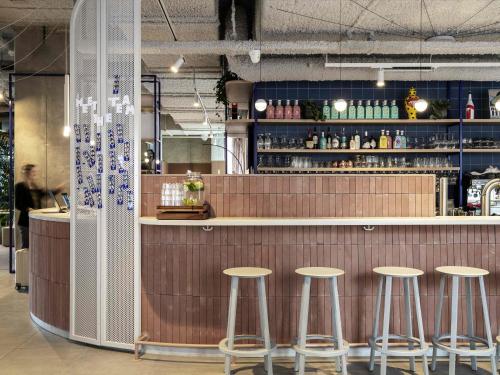 a bar in a restaurant with stools at a counter at Adagio Access Gent Centrum Dampoort in Ghent