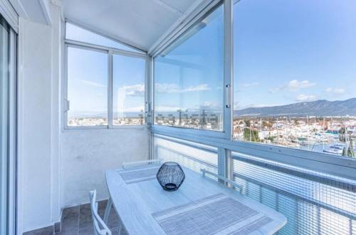 a white room with a table and some windows at Estudio Moderno la mejor vista al puerto deportivo in Empuriabrava