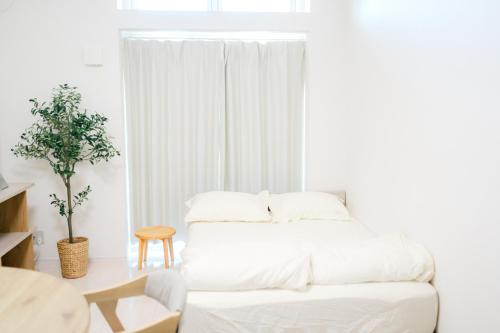 ein weißes Schlafzimmer mit einem weißen Bett und einem Tisch in der Unterkunft Greenfield - Vacation STAY 20422 in Hayaki