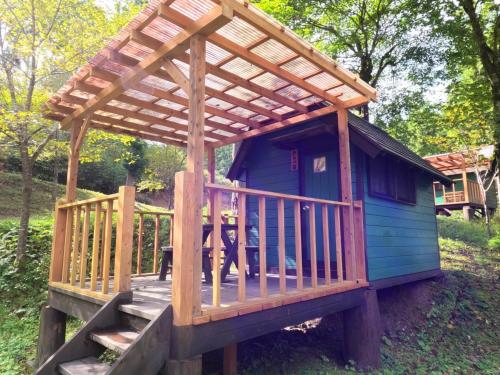a wooden house with awning on a deck at Nikko Manaka Forest Camp & Resort - Vacation STAY 65320v in Nikko
