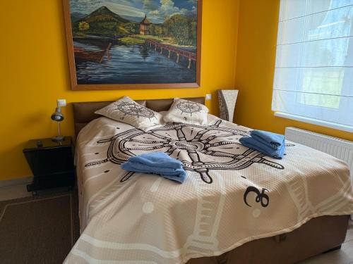a bedroom with a bed with a painting on the wall at Apartament przy polu golfowym in Niesulice