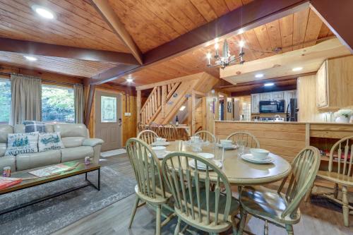 a dining room and living room with a table and chairs at Cabin with Hot Tub 2 Mi to Downtown Gatlinburg! in Gatlinburg