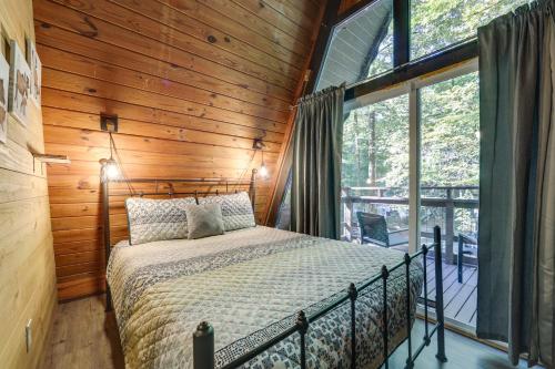 a bedroom with a bed and a large window at Cabin with Hot Tub 2 Mi to Downtown Gatlinburg! in Gatlinburg