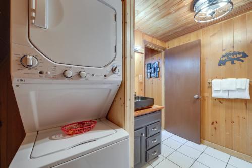 a small bathroom with a washer and dryer at Cabin with Hot Tub 2 Mi to Downtown Gatlinburg! in Gatlinburg