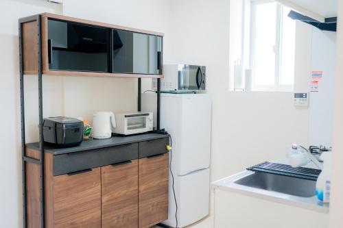 a kitchen with a refrigerator and a microwave at Greenfield - Vacation STAY 20427 in Sasebo