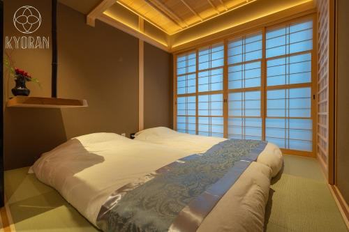 ein Schlafzimmer mit einem großen Bett vor einem Fenster in der Unterkunft [Kyoran Touen Residence] - Vacation STAY 65169v in Kyōto