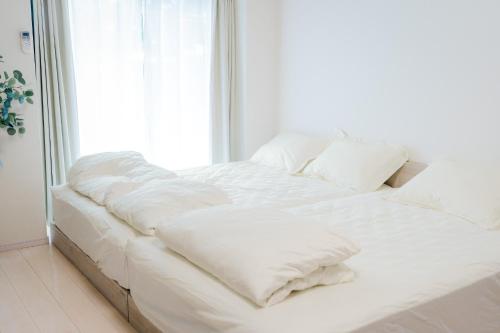 ein weißes Bett mit Kissen auf dem Zimmer in der Unterkunft Greenfield - Vacation STAY 20427 in Hayaki