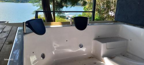 a white bath tub with two seats in front of a window at Villa Lake Blue in El Peñol
