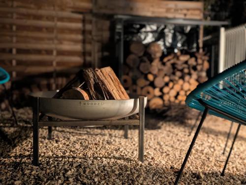 a bowl filled with wood sitting next to a bench at Studio cosy avec brasero, pour un séjour détente in Roquevaire