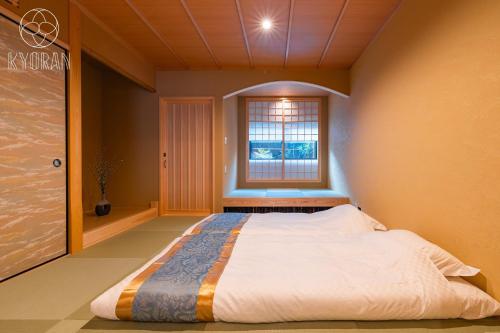 ein Schlafzimmer mit einem großen Bett mit Fenster in der Unterkunft Kyoran Yuzen - Vacation STAY 65318v in Kyōto