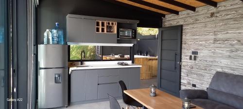 a kitchen with a refrigerator freezer next to a table at Villa Lake Blue in El Peñol