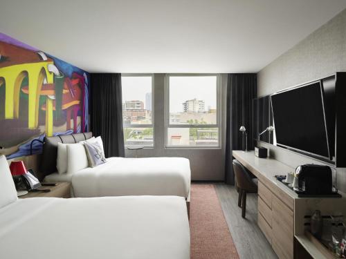 een hotelkamer met twee bedden en een flatscreen-tv bij Mondrian Mexico City Condesa in Mexico-Stad