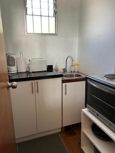 a small kitchen with a sink and a microwave at Depto Independiente Mostazal in La Punta