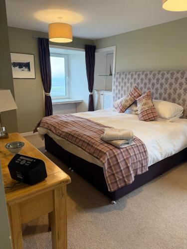 a bedroom with a large bed and a table at North Coast Property - Thurso Beachfront Apartment in Thurso