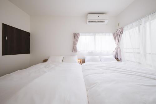 1 Schlafzimmer mit 2 weißen Betten und einem TV in der Unterkunft Kitakoiwakotate - Vacation STAY 20435 in Tokio