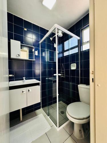 a bathroom with a toilet and a glass shower at Apartamento Balneário Picarras vista mar, centro in Piçarras